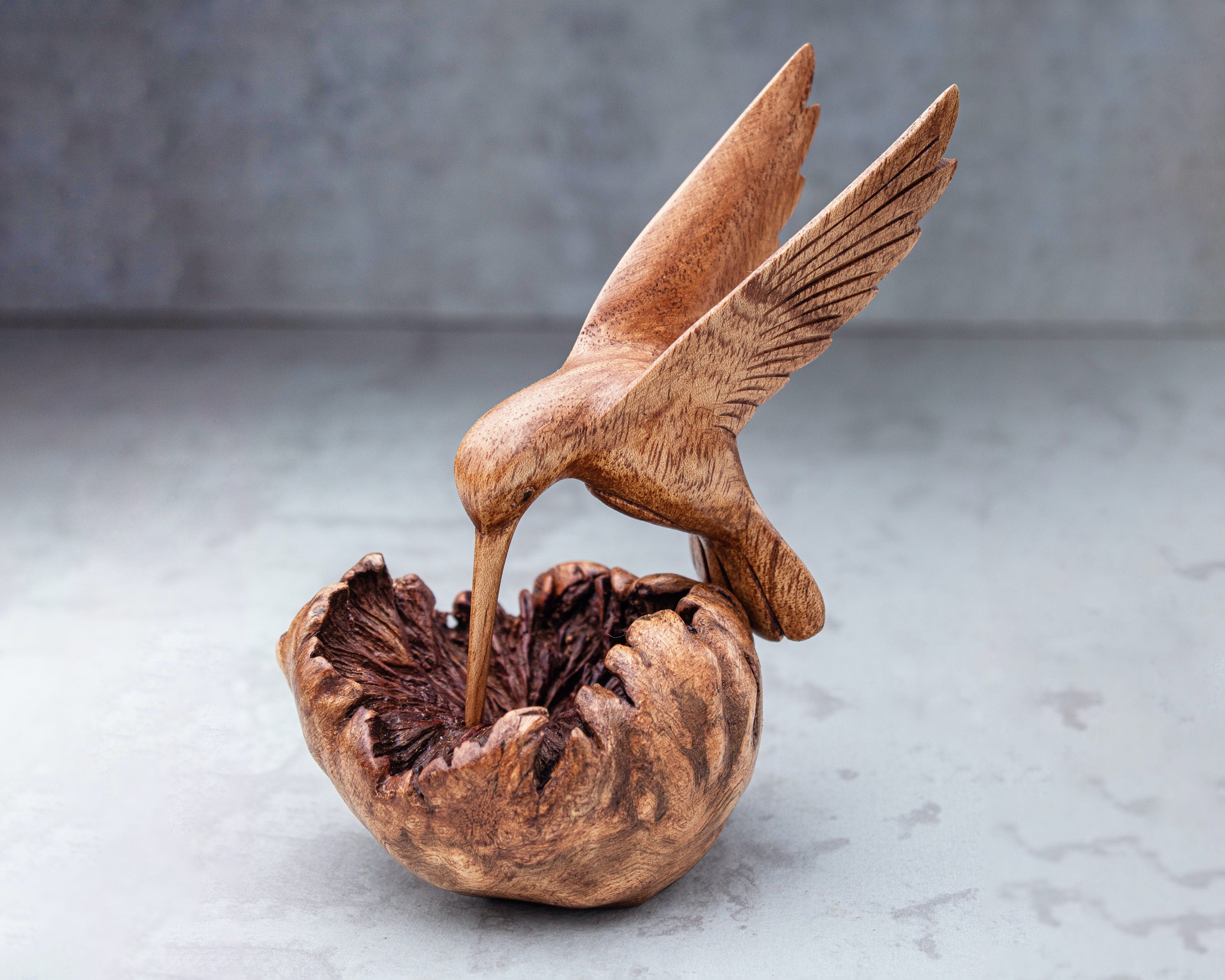 Hand-carved wooden hummingbird building nest sculpture