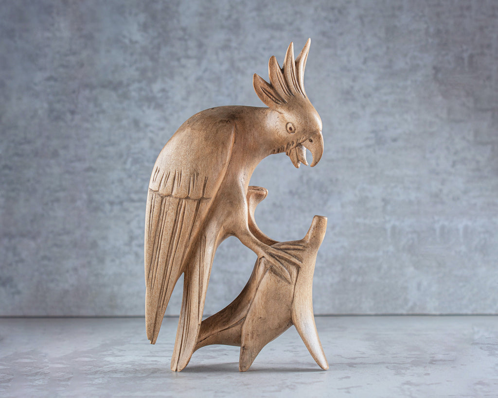 Wooden parrot sculpture on a gray background